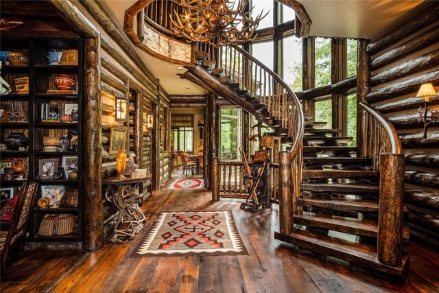 1090 Zeb Alley Rd, Cashiers, NC 28717 - stairway featuring hardwood / wood-style floors, a chandelier, plenty of natural light, and a towering ceiling