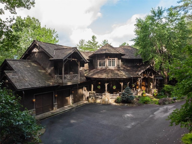 1090 Zeb Alley Rd, Cashiers, NC 28717 - view of front facade with a balcony, asphalt driveway, and an attached garage