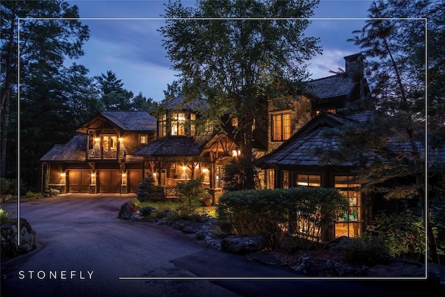 1090 Zeb Alley Rd, Cashiers, NC 28717 - view of front facade with a chimney, asphalt driveway, and stone siding