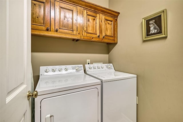 washroom featuring cabinet space and separate washer and dryer