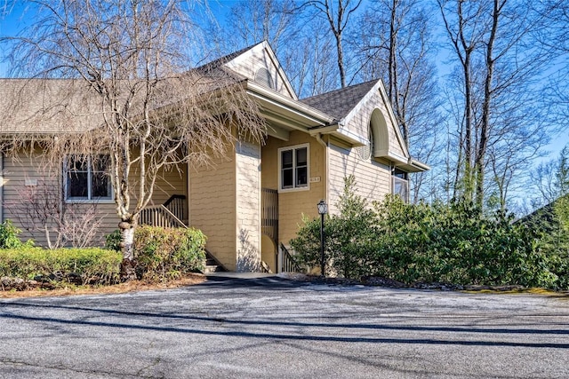 view of property exterior with roof with shingles