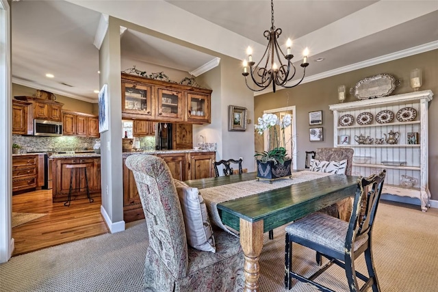 dining space with light carpet, recessed lighting, an inviting chandelier, and ornamental molding