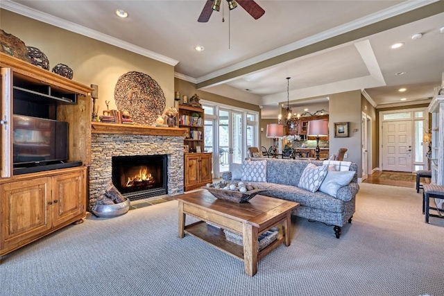 carpeted living area with recessed lighting, a stone fireplace, ornamental molding, and ceiling fan with notable chandelier