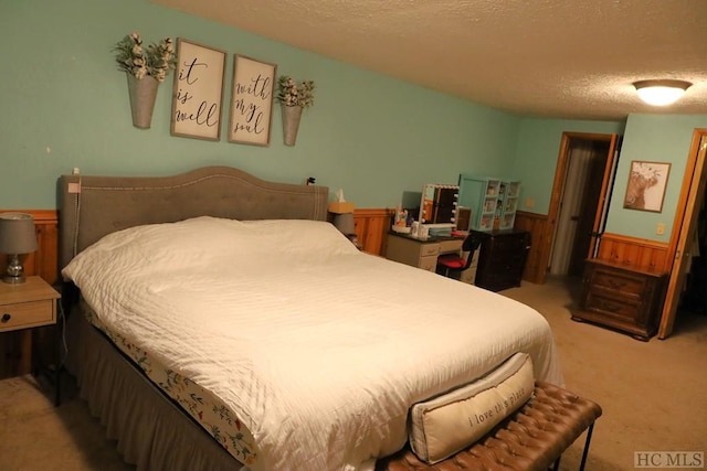 carpeted bedroom featuring a textured ceiling and wooden walls