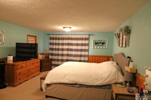 bedroom with a textured ceiling and light colored carpet