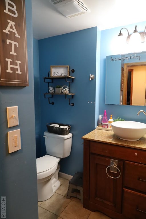 bathroom with tile patterned flooring, vanity, and toilet