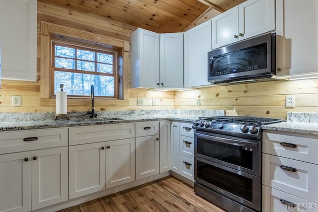 kitchen featuring sink, wood ceiling, vaulted ceiling, appliances with stainless steel finishes, and white cabinets