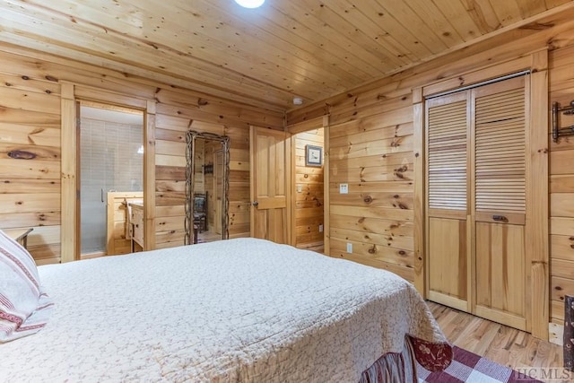 bedroom with wooden walls, light wood-type flooring, connected bathroom, and wood ceiling