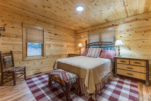 bedroom featuring wood ceiling, wooden walls, and light hardwood / wood-style floors