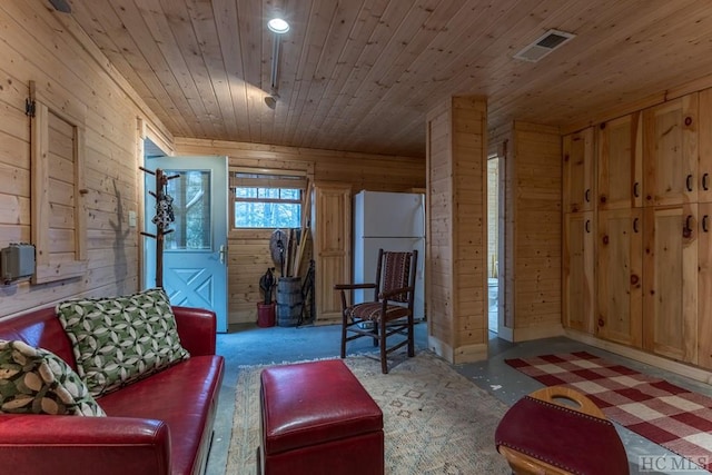 living room with wooden ceiling, dark carpet, and wood walls