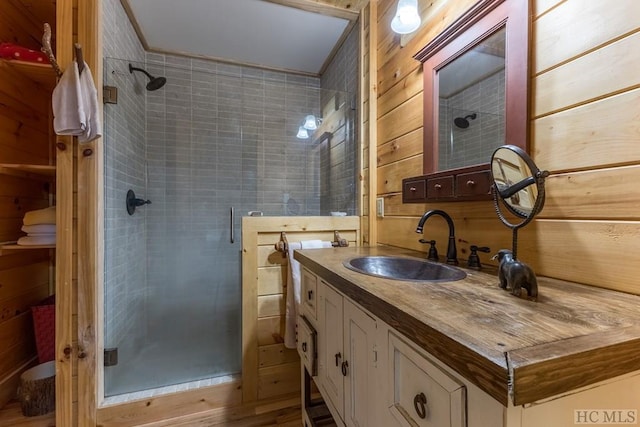 bathroom with vanity, an enclosed shower, and wood walls