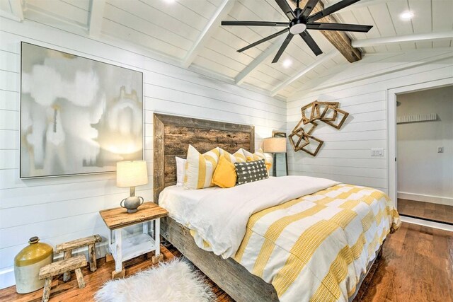 bedroom featuring vaulted ceiling with beams, a ceiling fan, wooden walls, and hardwood / wood-style floors