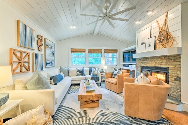 living room with wood finished floors, a fireplace, vaulted ceiling with beams, wood ceiling, and a ceiling fan