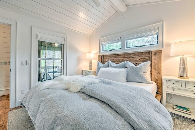 bedroom with baseboards, vaulted ceiling with beams, and wood finished floors