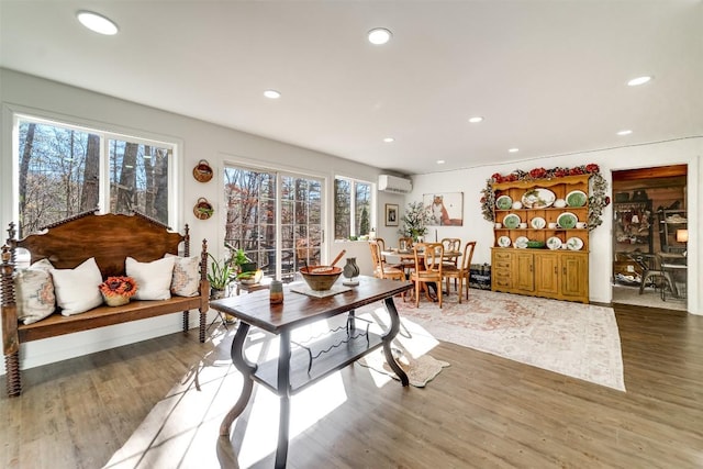 living room with a wall mounted air conditioner and dark wood-type flooring