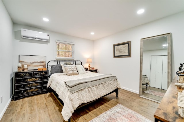 bedroom featuring a wall unit AC and light hardwood / wood-style flooring