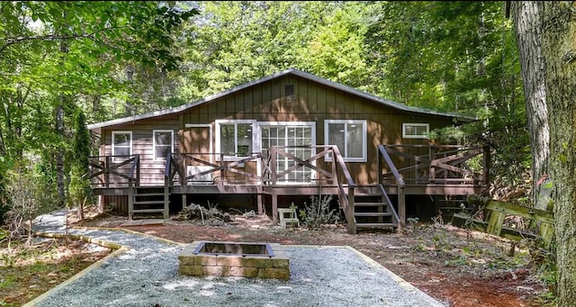 back of property featuring a deck and a fire pit