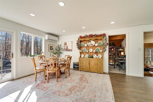 dining space featuring wood-type flooring and a wall unit AC