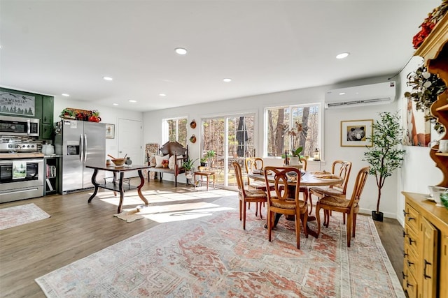 dining space featuring a wall mounted AC and hardwood / wood-style floors