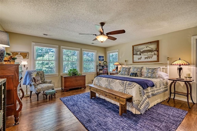 236 Hemlock Woods Dr, Highlands, NC 28741 - bedroom featuring a textured ceiling, wood finished floors, a ceiling fan, and a fireplace