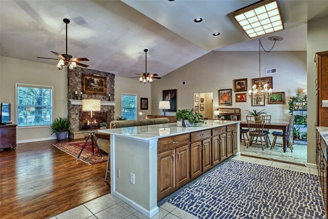 236 Hemlock Woods Dr, Highlands, NC 28741 - kitchen with ceiling fan, light countertops, a stone fireplace, open floor plan, and decorative light fixtures