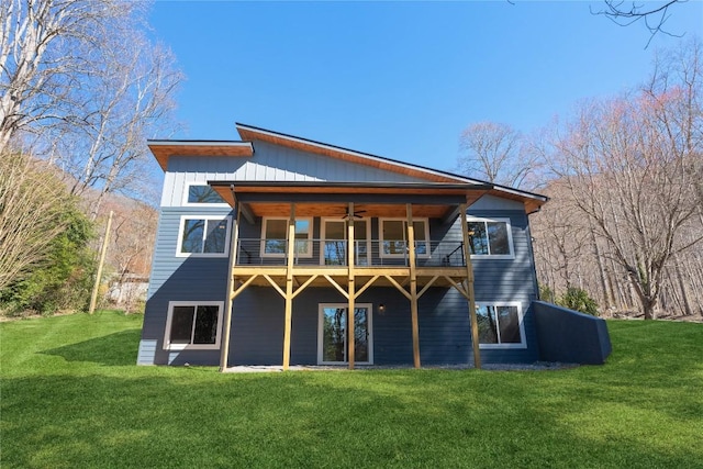 back of house featuring a lawn, a balcony, and a ceiling fan