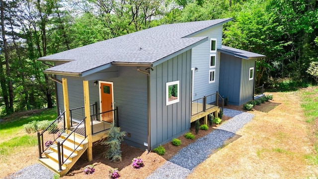 view of front facade with board and batten siding and a shingled roof