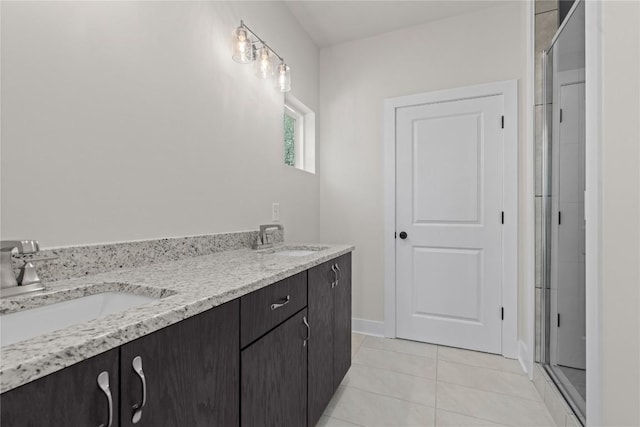 full bathroom featuring tile patterned flooring, a shower with shower door, baseboards, and double vanity
