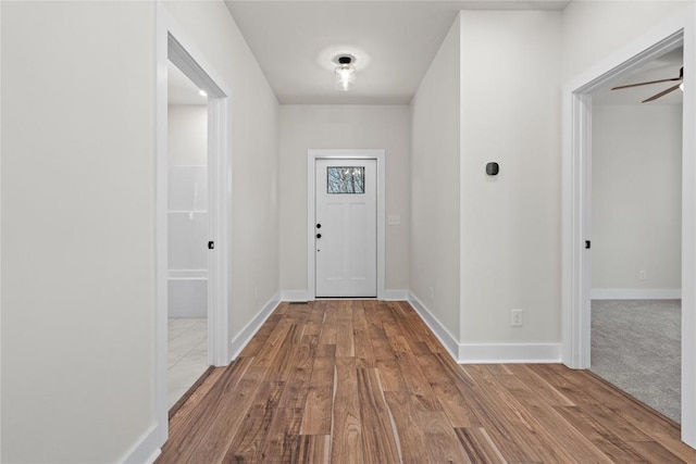 hall featuring wood finished floors and baseboards