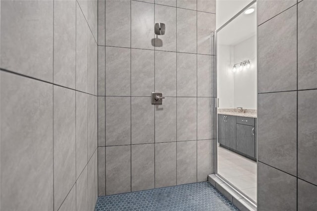 full bath with a tile shower and vanity