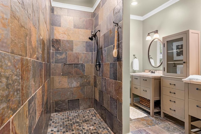 full bathroom featuring crown molding, stone tile floors, tiled shower, and vanity