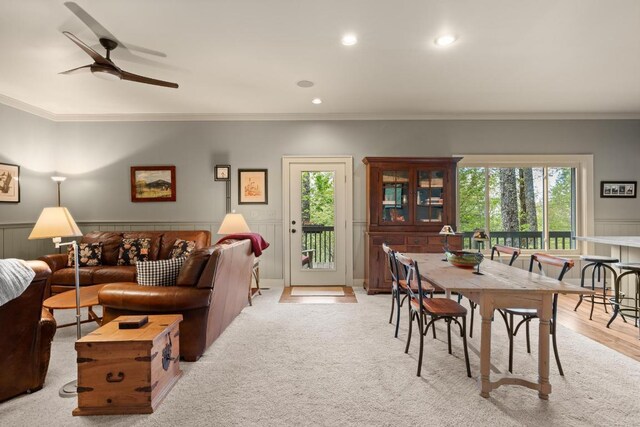 living room with crown molding, plenty of natural light, ceiling fan, recessed lighting, and wainscoting