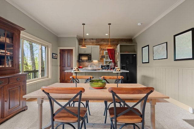 dining room featuring wainscoting, crown molding, light carpet, and recessed lighting