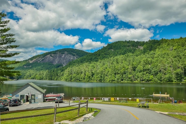 view of mountain background with a heavily wooded area and a nearby body of water