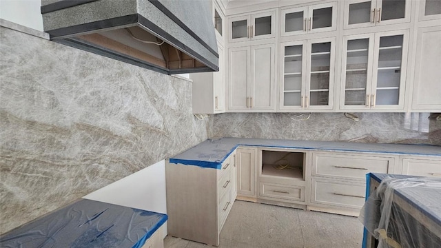 935 Glenshore Dr, Cullowhee, NC 28723 - kitchen featuring decorative backsplash, wall chimney range hood, glass insert cabinets, and light stone countertops