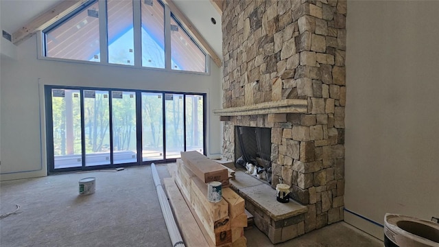 living area with beamed ceiling, high vaulted ceiling, and a stone fireplace