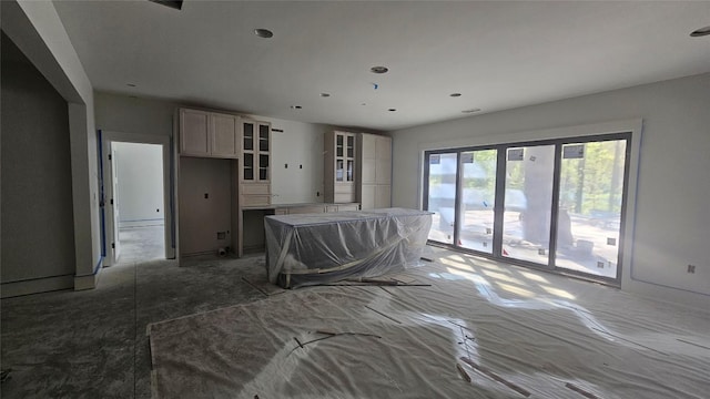 kitchen with glass insert cabinets, a baseboard radiator, a kitchen island, and recessed lighting