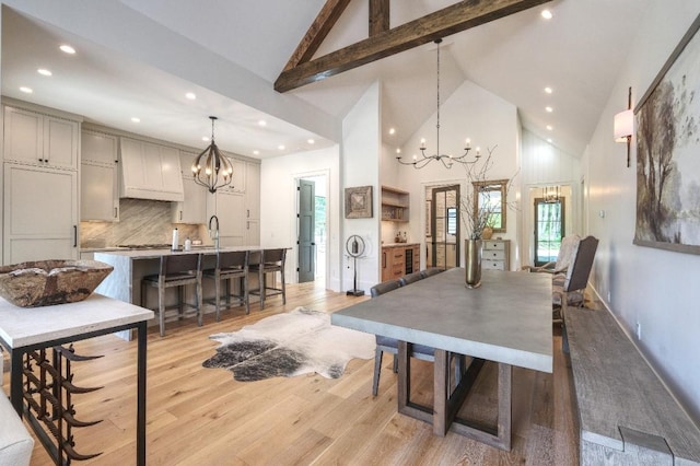 dining room featuring a chandelier, high vaulted ceiling, beamed ceiling, light wood-style floors, and recessed lighting