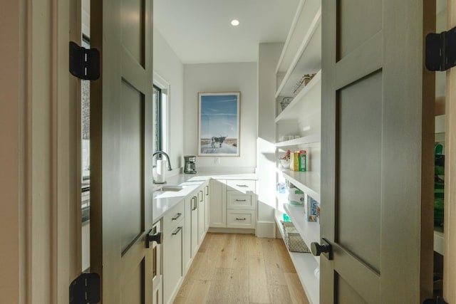 interior space with a sink, light wood-type flooring, and recessed lighting