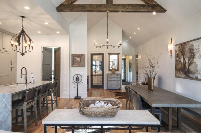 dining area featuring recessed lighting, light wood-style flooring, beam ceiling, and a chandelier