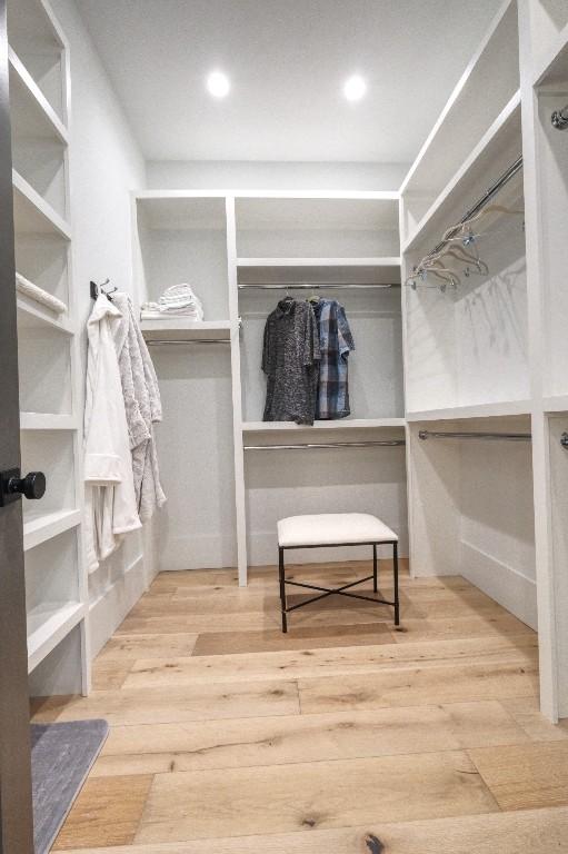 walk in closet with wood finished floors