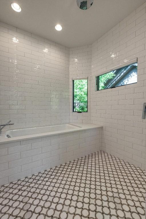 bathroom featuring tiled bath, recessed lighting, tile walls, and a tile shower