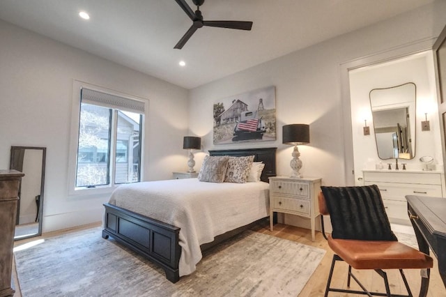 bedroom featuring wood finished floors, baseboards, recessed lighting, ceiling fan, and connected bathroom