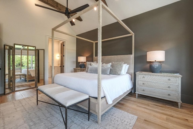 bedroom featuring high vaulted ceiling and wood finished floors