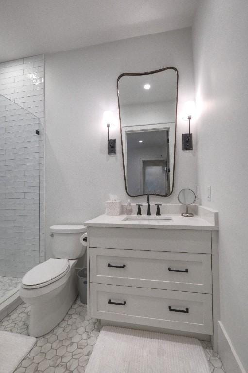 bathroom with toilet, a stall shower, and vanity