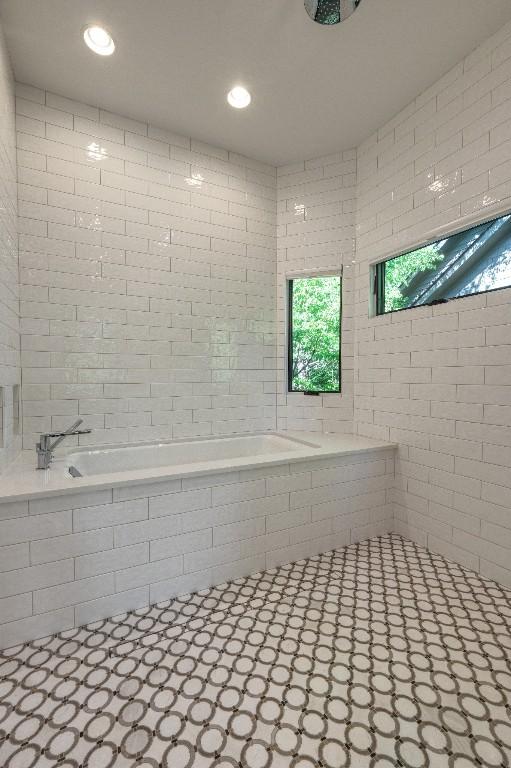 bathroom with tiled tub and recessed lighting