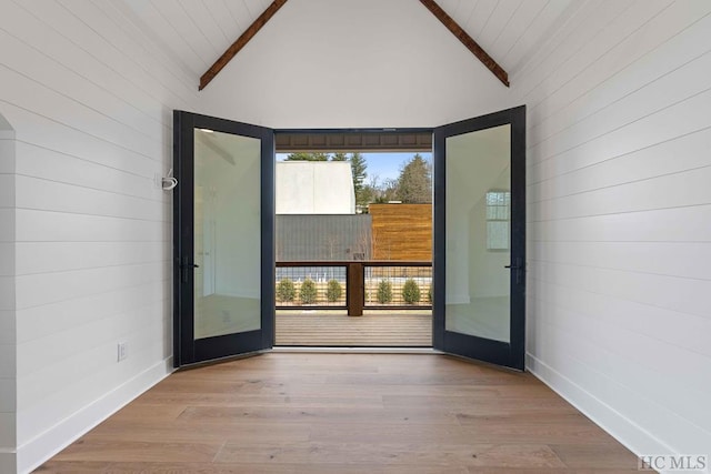 spare room with light wood-type flooring, beamed ceiling, high vaulted ceiling, and french doors