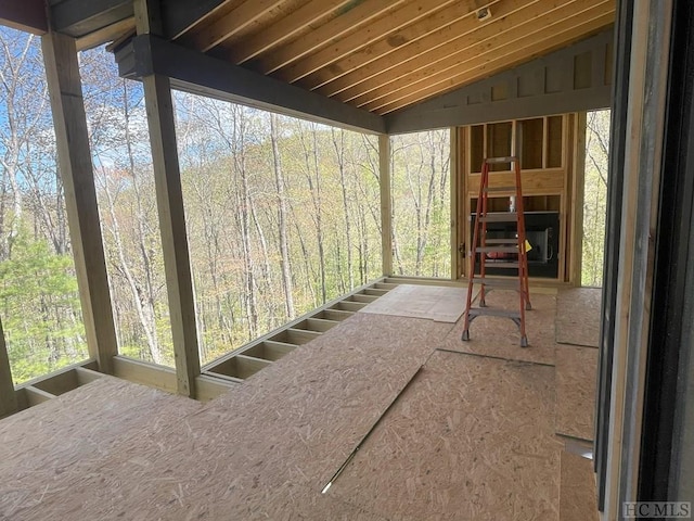 unfurnished sunroom featuring lofted ceiling and a healthy amount of sunlight