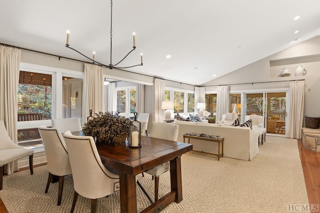 dining area featuring light carpet, lofted ceiling, and a notable chandelier