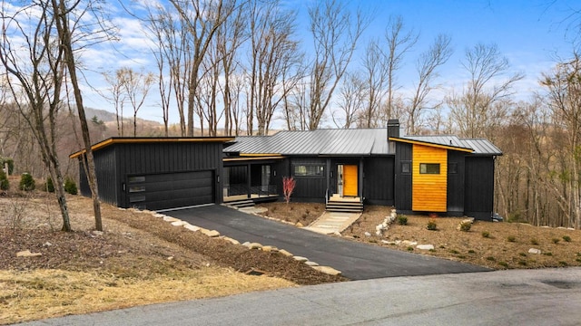 99 Springhead Trl, Cullowhee, NC 28723 - mid-century modern home featuring metal roof, driveway, a chimney, and an attached garage
